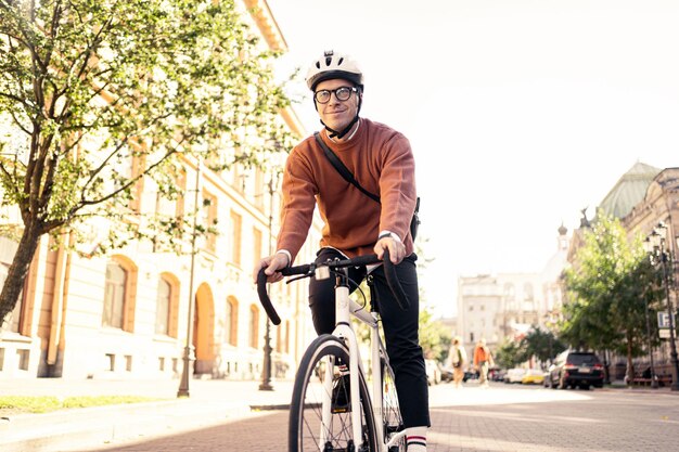 A pessoa é um freelancer com uma maleta em um capacete um ciclista indo para o trabalho de transporte ecológico