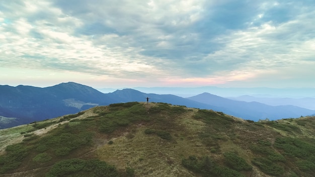 A pessoa em pé na montanha com uma paisagem pitoresca