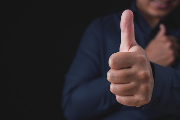 Foto a pessoa que usa camisa azul escura mostra os polegares para cima assalariado ou homem de negócios como ou bom conceito close-up tiro com espaço de cópia