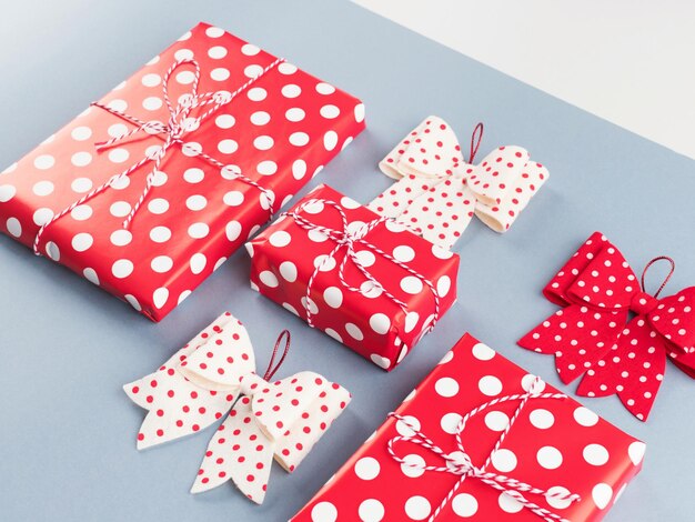 Foto a pilha de presentes de estilo vintage embrulhada em papel polka dot com laços em fundo azul de natal