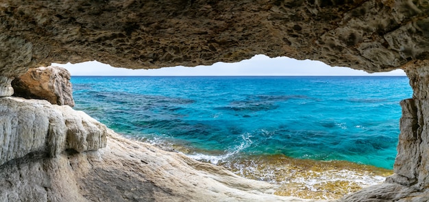 Foto a pitoresca caverna está localizada às margens do mar mediterrâneo.