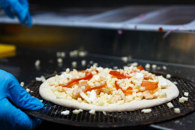 A pizza de queijo é instalada em um forno de esteira transportadora