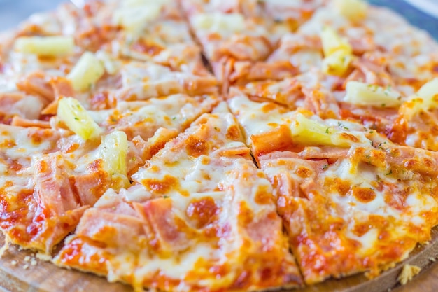 A pizza havaiana é uma comida italiana feita com molho de tomate, abacaxi picado, presunto e queijo.