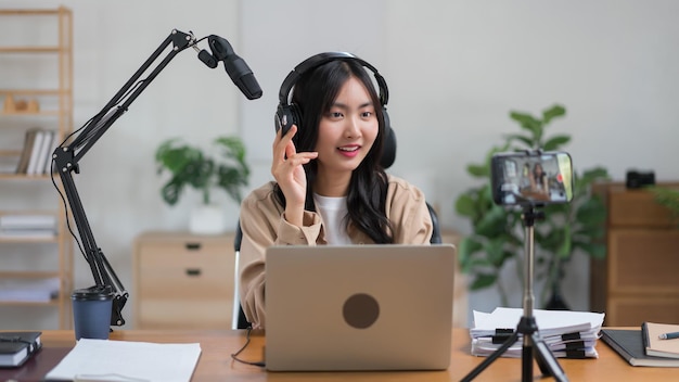 A podcaster feminina usa o microfone para conversar com o público e gravar o podcast de vídeo no smartphone