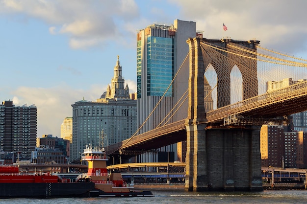 A ponte de brooklyn fica contra um céu azul arranha-céus no centro de manhattan