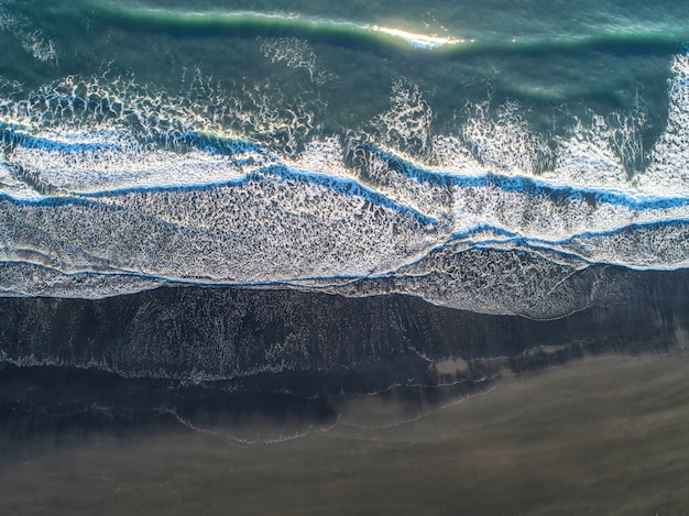 A praia de areia preta na Islândia. Vista aérea do mar e vista superior.