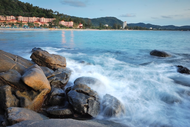 A praia rochosa, surf, lindo hotel em segundo plano.