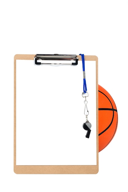 A prancheta de um treinador com uma folha de papel em branco, apito e lápis, repousa contra uma bola de basquete e é isolada no branco. Designers podem colocar uma cópia na folha de papel em branco