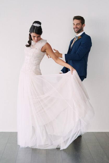 A primeira dança, mas não a última foto de estúdio de um jovem casal recém-casado em pé contra um fundo cinza