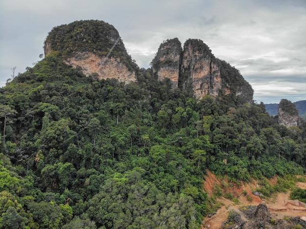 AÉREA: Vista aérea de tirar o fôlego das altas montanhas cobertas pela floresta tropical elevando-se sobre o vale vazio no coração de uma ilha exótica.