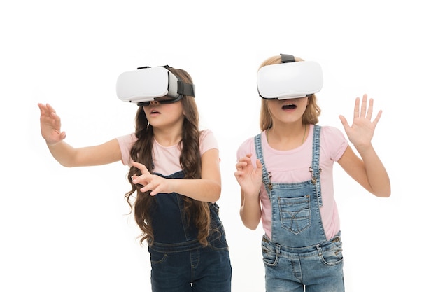 A realidade virtual é emocionante. meninas crianças usam óculos de fundo branco de vr. conceito de educação virtual. vida moderna. interação em espaço virtual. jogos cibernéticos. tecnologia de realidade aumentada.