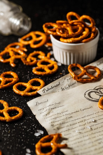 A receita para fazer pretzels está escrita em um pedaço de papel, ao lado dele está sal e pretzels.