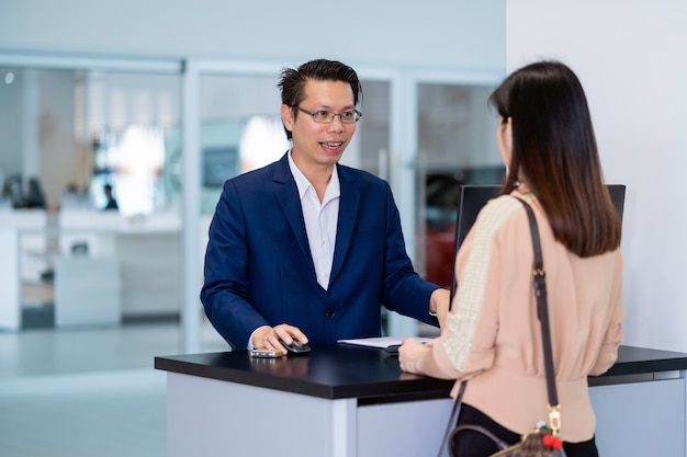 A recepcionista asiática recebeu a chave automática do carro para verificação no centro de manutenção no showroom