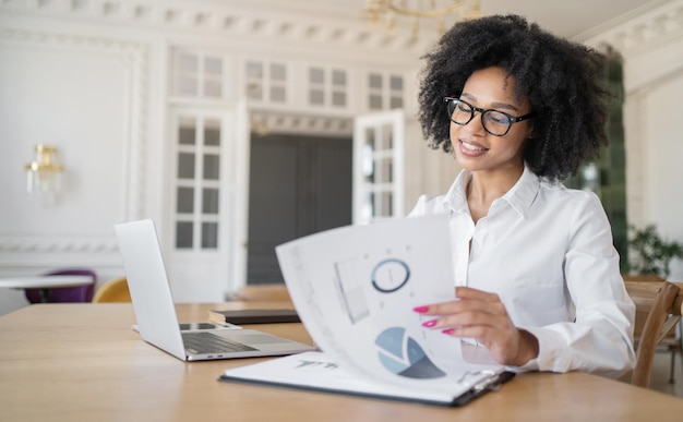 A recepcionista é uma mulher de óculos que trabalha no escritório fazendo um relatório com documentos na financeira