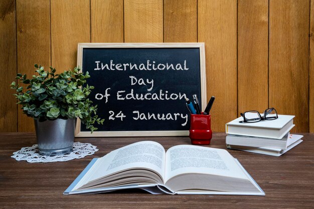 A representação do dia internacional da educação com livros e um caderno em uma mesa