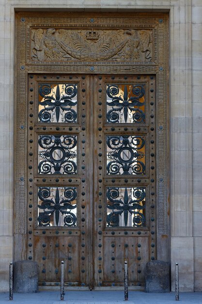 A rica decoração decora uma porta de entrada do antigo edifício de arquitetura tradicional no centro de Paris