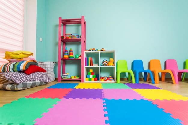 Foto a sala de jogos com móveis coloridos os brinquedos infantis são lindamente organizados em armários e tapetes coloridos no chão