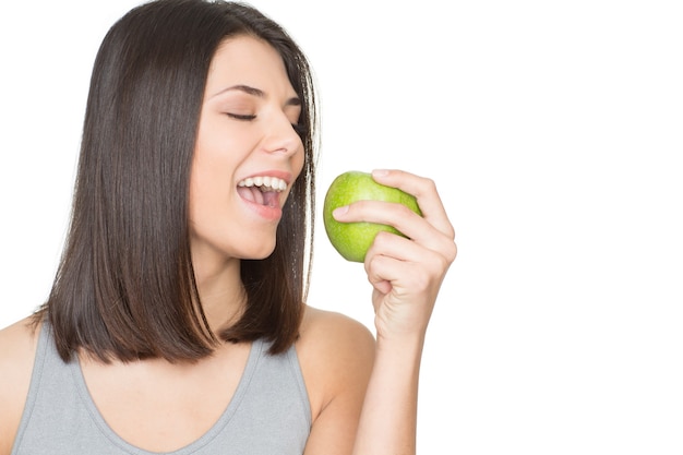 A saúde é incrível. Linda mulher jovem, feliz e saudável com uma maçã verde na mão, isolada em um branco copyspace ao lado