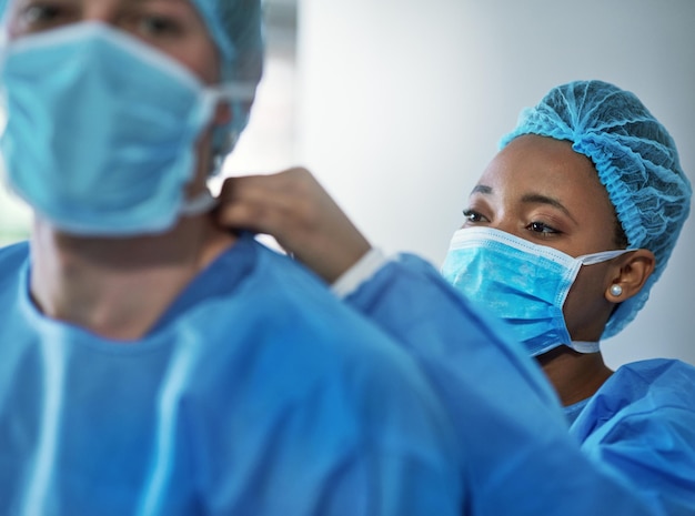 A segurança é fundamental em todos os procedimentos médicos Foto de cirurgiões vestindo roupas de proteção em preparação para uma cirurgia