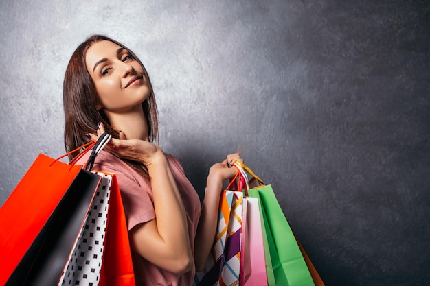 A senhora segura muitas sacolas nas mãos depois das compras