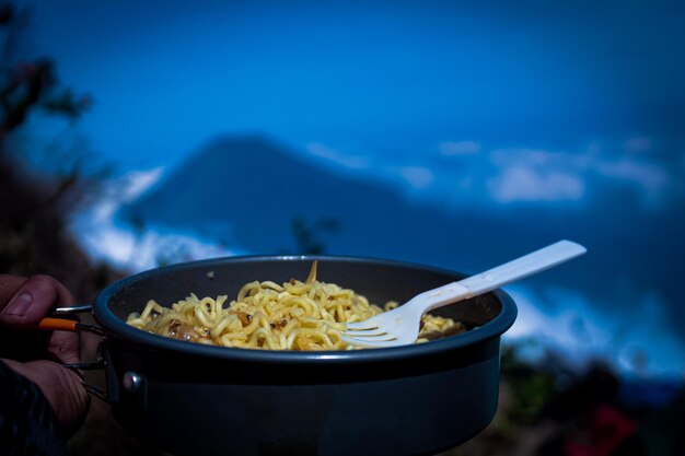 Foto a sensação de cozinhar macarrão na montanha.