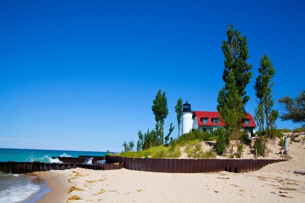 A serena costa de Michigan com o farol e a casa de Keeper39s