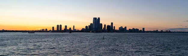 Foto a silhueta da cidade de jersey contra um dramático pôr-do-sol