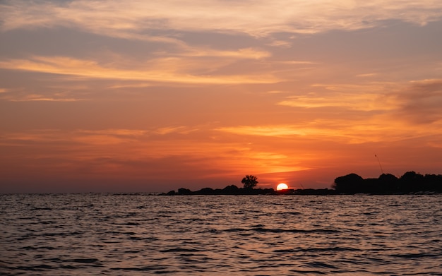 A silhueta da ilha no pôr do sol na ilha tropical na Tailândia