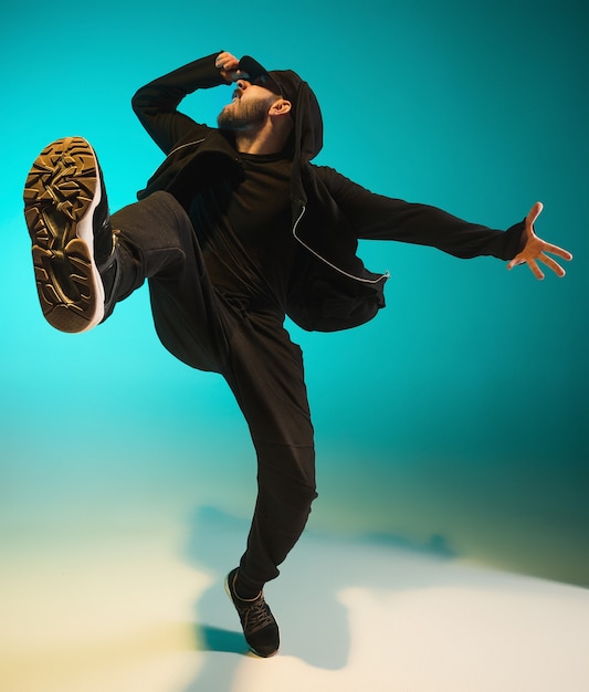 A silhueta de um jovem dançarino de break de hip hop dançando sobre fundo colorido