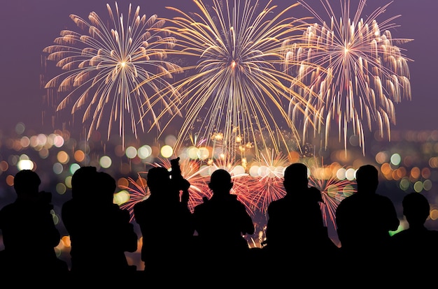 A silhueta do repórter fotografar os fogos de artifício coloridos fantásticos de ano novo festivo