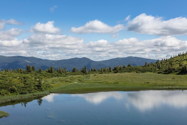 A superfície da água de um lago azul na perspectiva dos Cárpatos da cordilheira de Gorgan