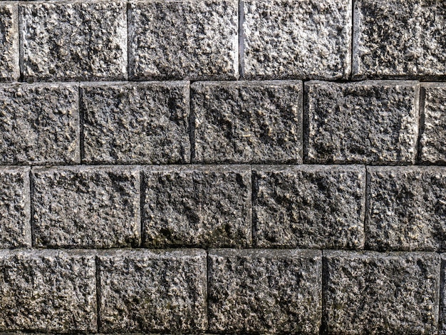 A superfície da parede é de tijolo branco, mas com muito tempo exposta ao sol e à chuva até velha e preta