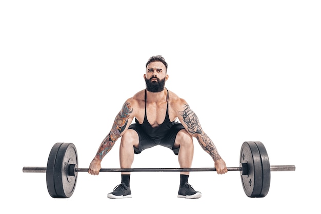 Foto a técnica de fazer um exercício de levantamento terra com uma barra de um musculoso forte tatuado em esportistas barbudos