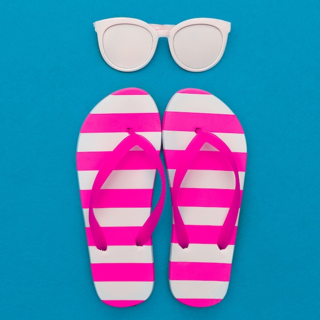 Foto a temporada de praia está aberta. estilo marinho. chinelos, listras, óculos de sol. arte minimalista