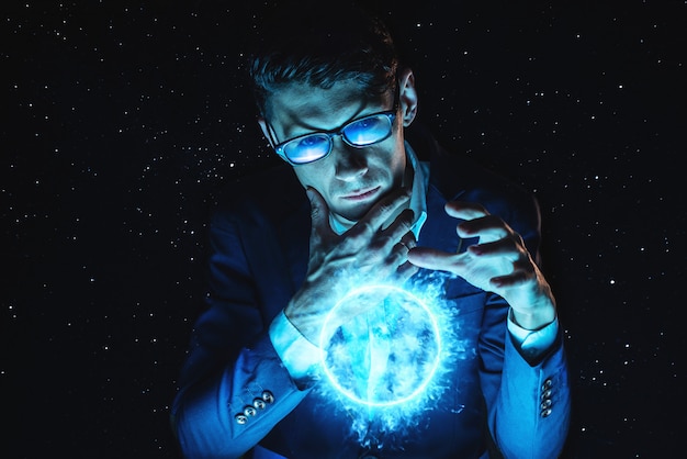 Foto a terra arrendada do homem de negócios do homem cede uma esfera de incandescência azul do plasma. previsão mágica e previsão em negócios e finanças