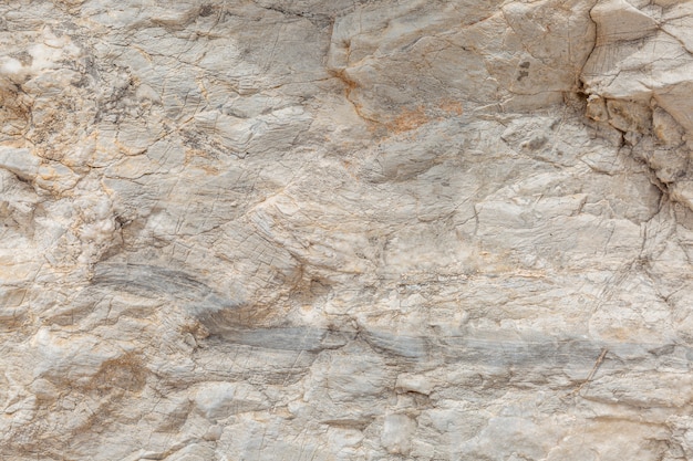 A textura da superfície da pedra natural, close-up. Material de construção de civilizações antigas. Fundo. Espaços para texto.