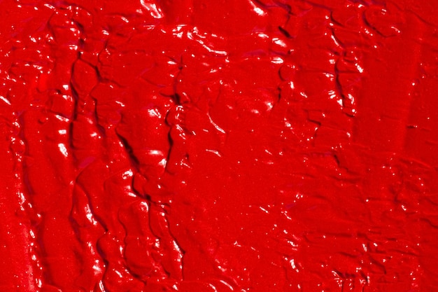 Foto a textura da tinta de brilho labial de batom completamente preenchida no fundo cor vermelha