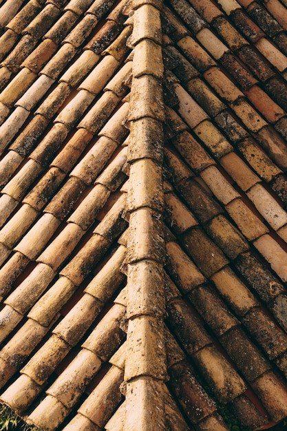 A textura das velhas telhas marrons no telhado do edifício