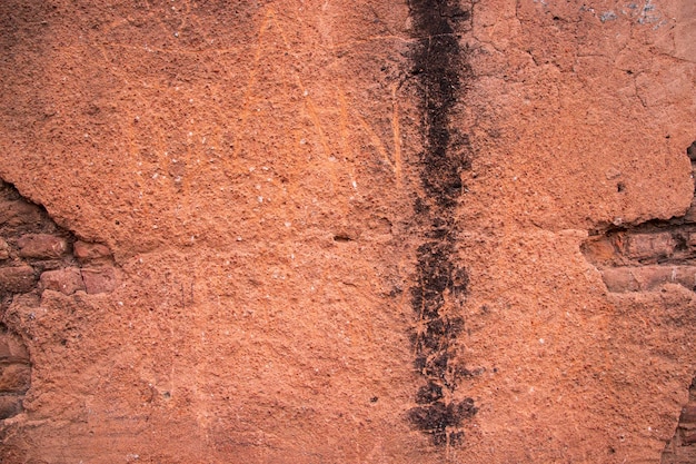 A textura de gesso vermelho da parede de tijolos antigos pode ser usada como papel de parede de fundo