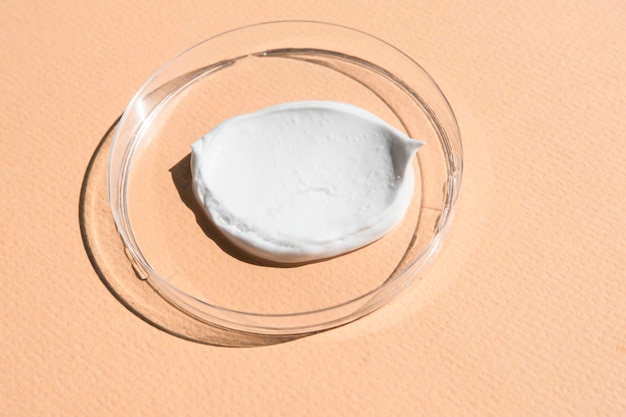 A textura de um creme cosmético branco sobre um fundo bege cuidado e hidratação
