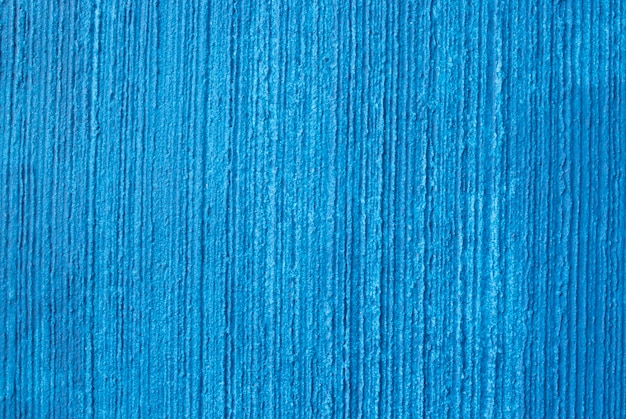 A textura de uma parede rebocada pintada no fundo azul do conceito