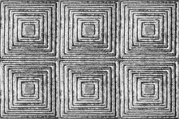 A textura de uma superfície de metal com um teste padrão sob a forma dos quadrados e dos rhombuses em preto e branco.
