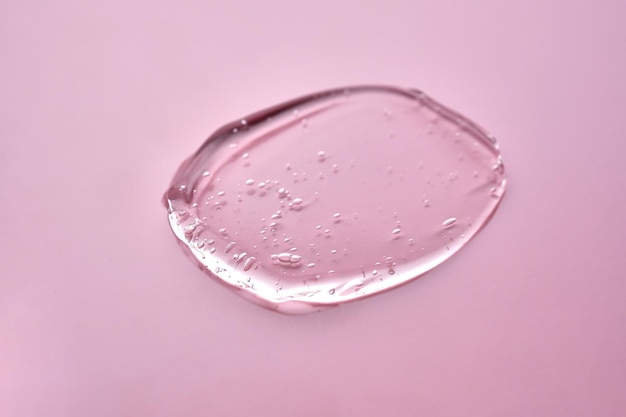 A textura do gel cosmético sobre um fundo rosa