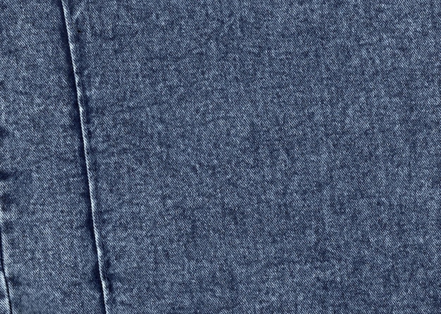 A textura do tecido denim feito de fibras de algodão azul dos fios de um pequeno padrão