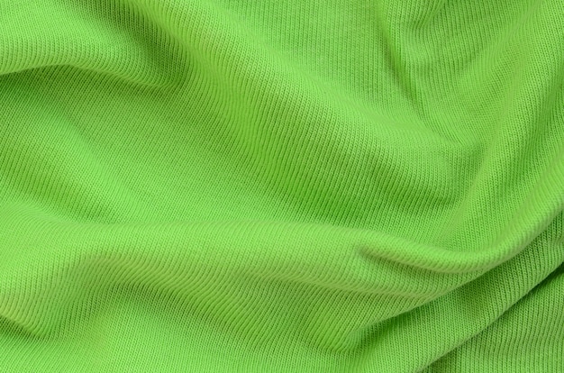 A textura do tecido é verde brilhante. Material para fazer camisas e blusas