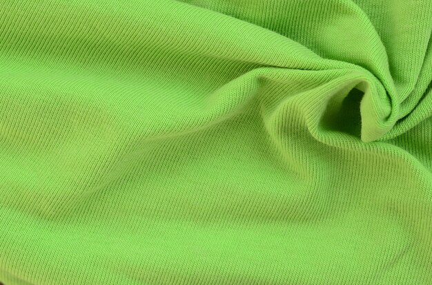 A textura do tecido é verde brilhante. Material para fazer camisas e blusas