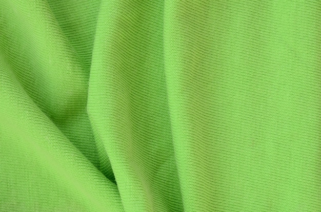 A textura do tecido é verde brilhante. material para fazer camisas e blusas