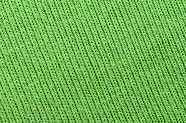 A textura do tecido é verde brilhante. Material para fazer camisas e blusas