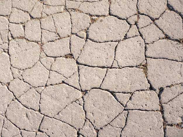 A textura do velho asfalto com rachaduras.