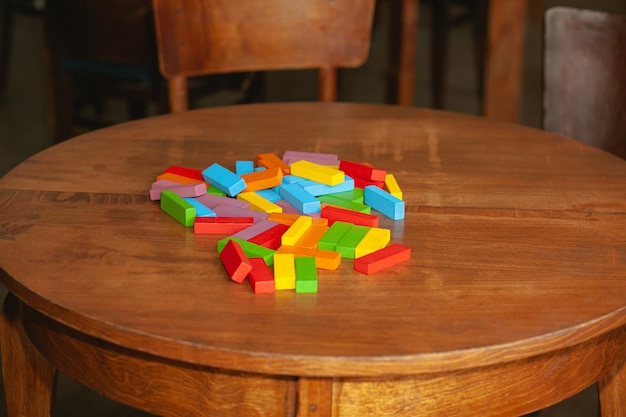 A torre arruinada do jogo Jenga Blocos coloridos espalhados na mesa